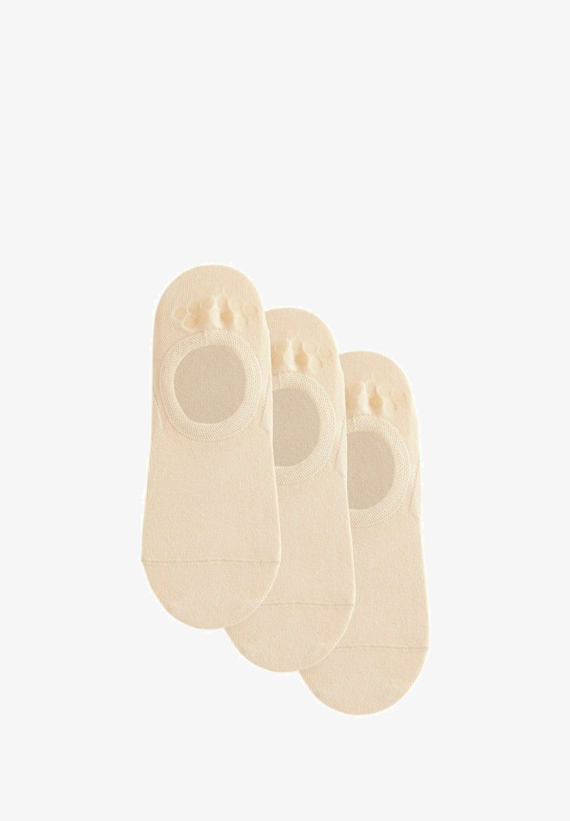 Beiga, låga strumpor gjorda av mjukt tyg. Har ett cirkulärt urtag vid toppen och texturerade greppprickar på hälen för stabilitet.