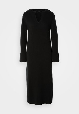 Rochie tricotată neagră cu decolteu în V și mâneci lungi, având manșete cu nervuri. Designul are o siluetă dreaptă și o tăietură până la genunchi.