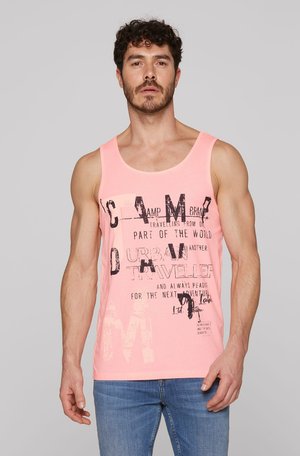 Pink cotton tank top featuring graphic text print in black. Round neckline, wide armholes, and a relaxed fit, paired with blue jeans.