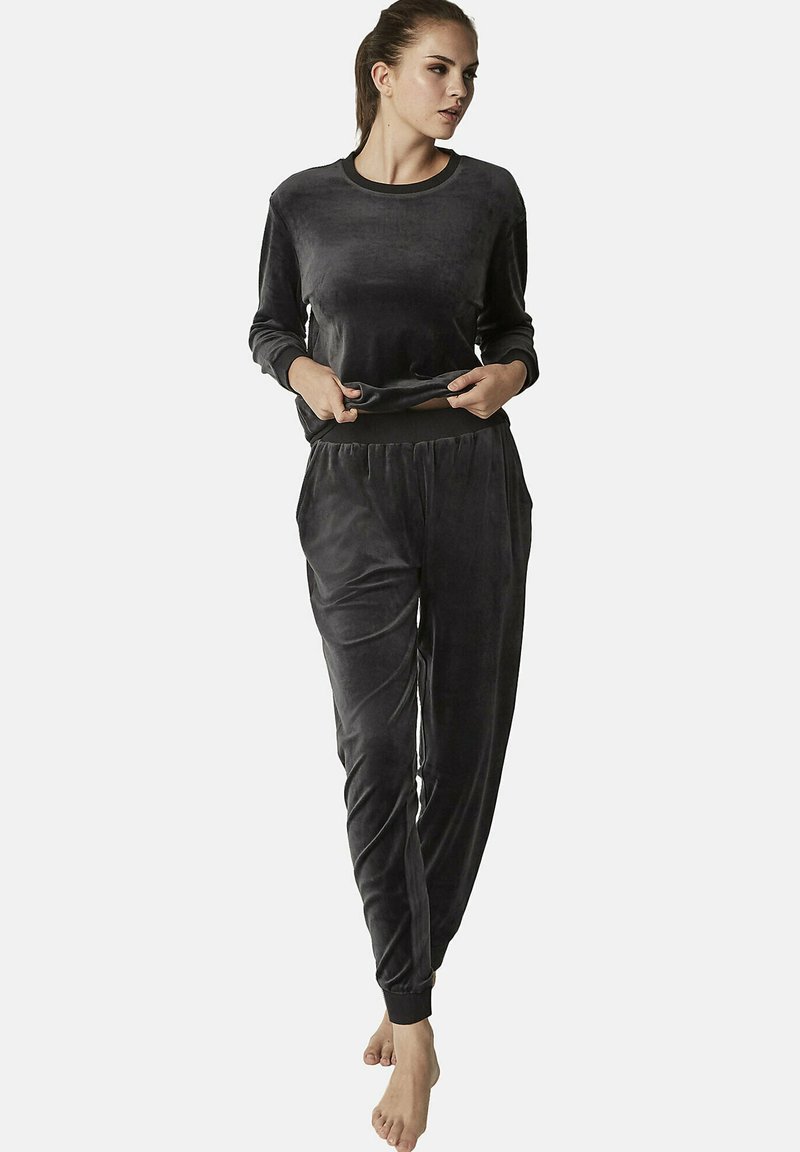 Donkergrijs velours loungewear-set met een langemouwen top en broek met elastische tailleband en zakken. Zachte textuur en aflopende beenontwerp.