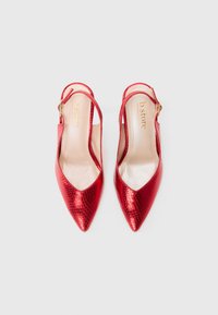 Røde slingback hæle med spids tå, der har en skinnende præget tekstur. Justerbar rem med en guldtonet spænde. Glat indvendig foring.