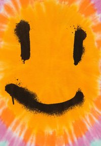 Keltainen tikkikangas, jossa on suuri mustalla spraymaalilla tehty hymyilevä naama -kuvio, sekä roiskeita ja tekstuuri-efekti.