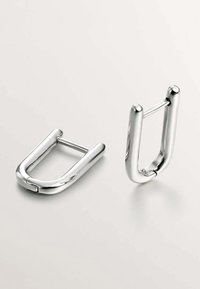 Hebillas de metal con un acabado plateado pulido, diseño en forma de U, bordes redondeados y un pasador central, que presentan una textura suave y brillante.