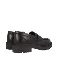 Zapatos negros de piel de tipo slip-on con una suela de goma texturizada y baja. Presentan una puntera redondeada y detalles de costura mínimos en la parte superior.