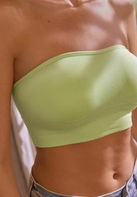 Žalias strapless trumpas viršus, pagamintas iš tamprios medžiagos, su raukšlėta tekstūra apykrityje ir lygiu paviršiumi.