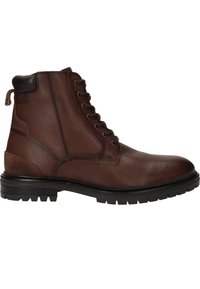 Bottine en cuir marron avec une finition texturée, un design à lacets et un talon sombre contrastant. Dotée d'une semelle robuste avec des rainures de traction.