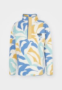 Pull en polaire avec motif floral en bleu, jaune et blanc. Il dispose d'un col montant, de quatre boutons et d'une petite poche poitrine.