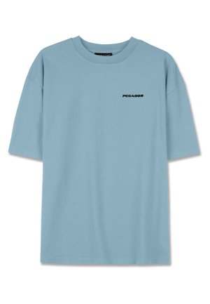 T-shirt di cotone azzurro chiaro con vestibilità ampia, maniche corte e logo nero "PEGADOR" sul petto. Tessuto morbido, senza ulteriori fantasie.