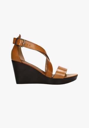 Sandale compensée en cuir tanné de couleur marron clair avec semelle noire, bride de cheville avec boucle et lanières croisées à l'avant, vue de profil latéral.