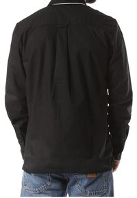 Schwarzes Langarmshirt mit Schlitzdetail am Rücken, geknöpften Manschetten und kontrastierender weißer Kragenbesatz. Lässiges Design und weiche Textur.