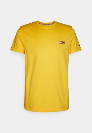 Żółta koszulka z krótkim rękawem i okrągłym dekoltem, małe logo "Tommy Jeans" na lewej piersi oraz małe logo flagi na lewym rękawie.