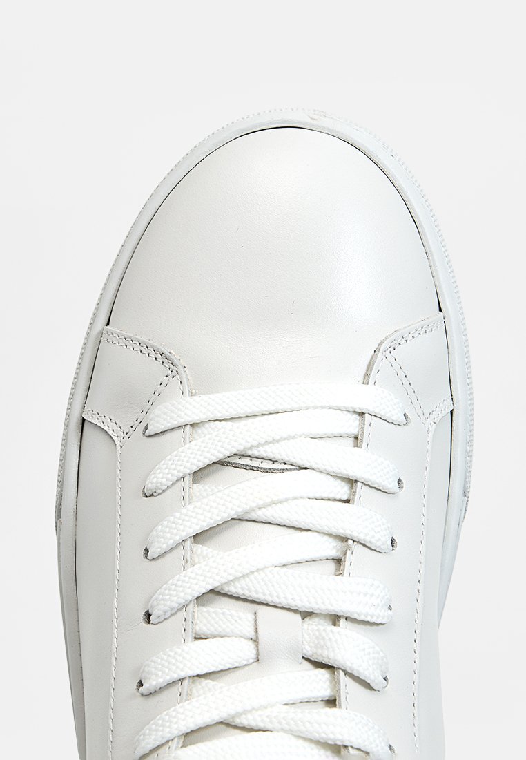 Weiße Ledersneaker mit abgerundetem Zeh, strukturiertem Obermaterial und flachen weißen Schnürsenkeln. Hat ein minimalistisches Design und keine sichtbare Markenkennzeichnung.