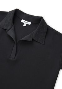 Černé polo tričko vyrobené z hladké tkaniny, které má límeček s texturovanými detaily a zakomponovanými kamínky pro zdobení.