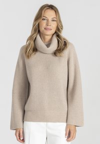 Beżowy sweter z golfem, pleciony w prążki, z szerokimi rękawami i dopasowanym dołem. Miękka tekstura i minimalistyczny design.