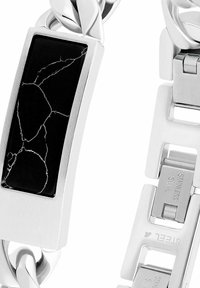 Pulsera de acero inoxidable con incrustación de piedra negra rectangular con vetas plateadas, diseño enlazado y textura de metal cepillado.