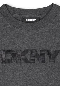 T-shirt gris foncé avec un col rond côtelé et un logo "DKNY" noir en relief avec des rayures verticales sur les lettres.