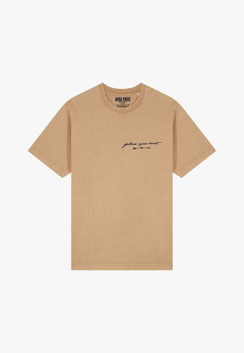 Bežs kokvilnas T-krekls ar īsām piedurknēm, apaļu kaklu. Uz krūtīm ir melnā slīprakstā drukāts teksts "seko savai sirdij".