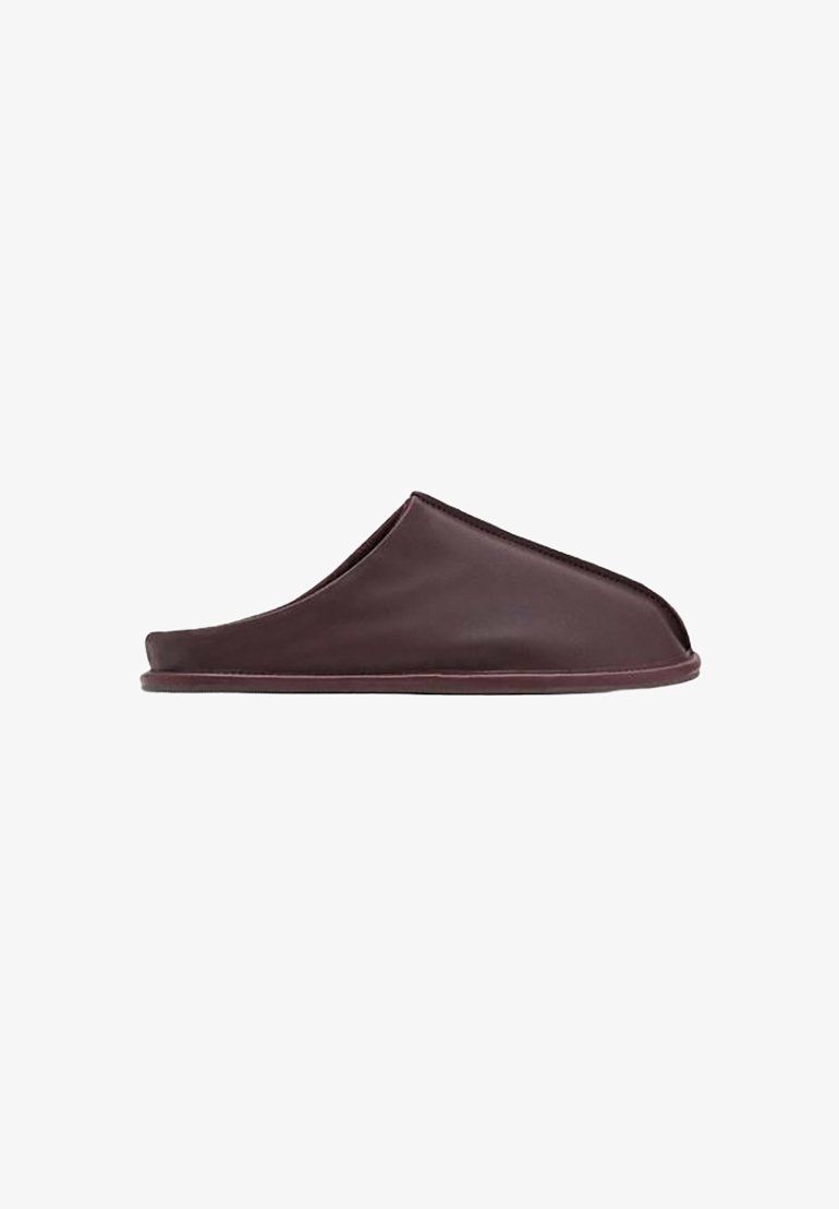 Dark brown slipper with a smooth, leather-like material, open back design, rounded shape, and subtle stitched accents along the edges.