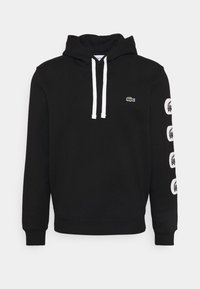 Felpa nera con cappuccio e lacci, con un logo verde sul petto e dettagli bianchi stampati sulle maniche. Tessuto morbido.