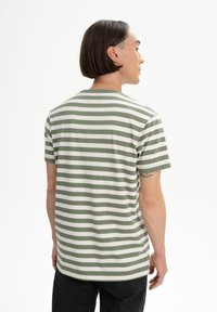 Grün-weiß gestreiftes T-Shirt mit kurzen Ärmeln, Rundhalsausschnitt und geradem Schnitt, aus weichem Baumwollmaterial gefertigt, mit einem minimalistischen Design.