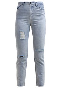 Vaaleansiniset korkeavyötäröiset kapeat farkut, joissa on revittyjä kohtia vasemmassa reidessä, oikeassa polvessa ja vasemmassa sääressä. Farkuissa on etutaskut ja vyölenkit.