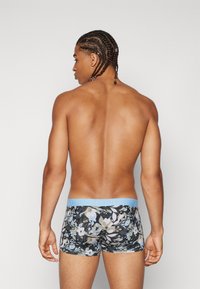 Boxer con un motivo floreale in colori tenui, con un elastico azzurro chiaro. Il materiale sembra morbido ed elastico.