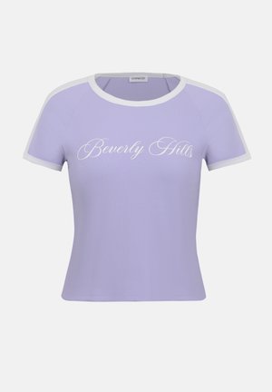 Λιλά ριμπ πλεκτό τοπ με κοντά μανίκια και λευκό τελείωμα, με κείμενο "Beverly Hills" σε καλλιγραφικό στυλ στο κέντρο του στήθους.