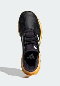 Czarne buty sportowe z kamuflażem, górna część w kolorze czarnym i purpurowym oraz teksturowana gumowa podeszwa w kolorze gumy. Posiadają trzy białe paski.