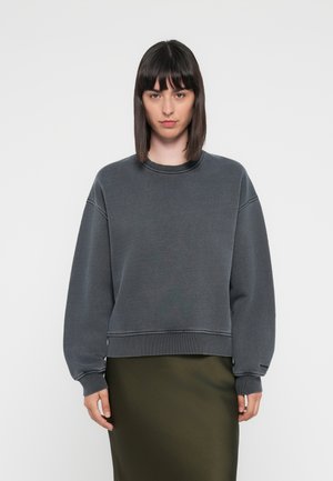 Donkergrijze sweatshirt met een ronde hals, losse pasvorm, geribbelde boorden en een strak ontwerp, gecombineerd met een olijfgroene, aansluitende rok.