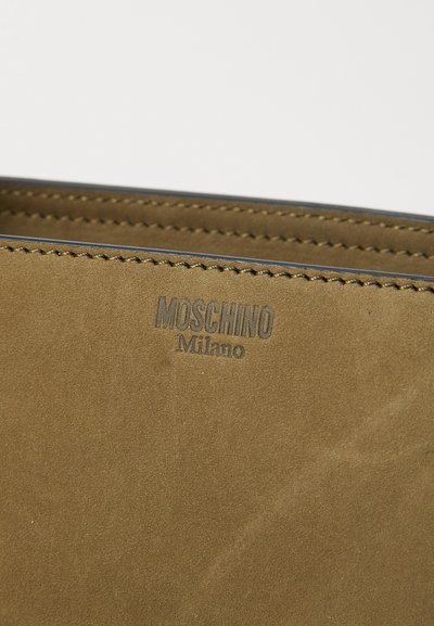 Portafoglio in suede marrone con logo "Moschino Milano" impresso, caratterizzato da linee pulite, cuciture in vista e una superficie liscia.
