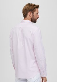 Lichtroze gestreepte shirt van katoen, met een klassieke kraag, lange mouwen en een middenachter plooi voor extra ontwerpdetails.