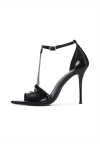Sandale à talon haut en cuir verni noir, avec un orteil ouvert, un design en T, un accent en chaîne argentée et une bride ajustable à la cheville.