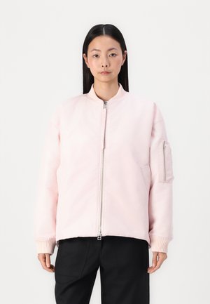 Light pink bomber jacket with a high collar, front zipper, and ribbed cuffs. Features a zippered pocket on the left sleeve. Smooth texture.
