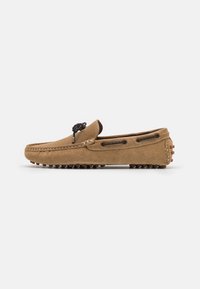 Braune Wildleder-Mokassinschuhe mit abgerundeter Spitze, schwarzen Schnürdetails und einer Gummisohle im Kieselstein-Design für besseren Halt. Keine sichtbaren Muster oder Akzente.