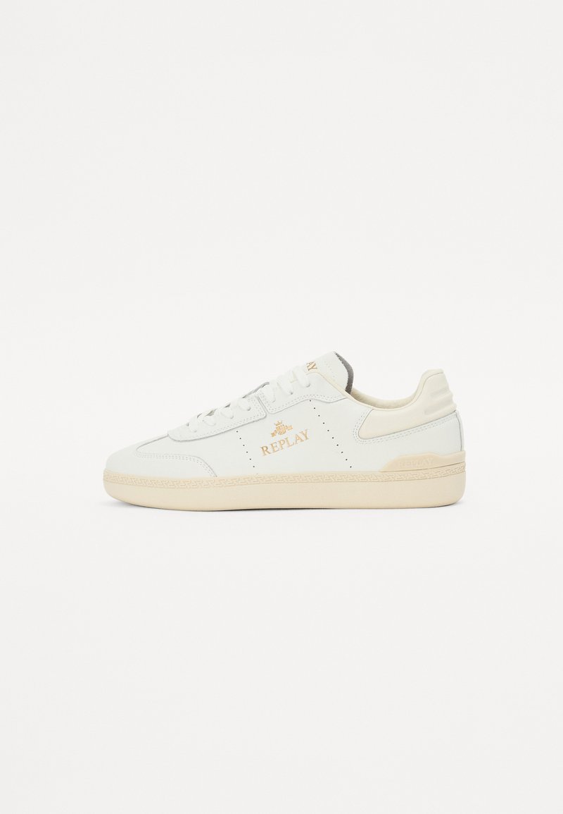 White leather sneaker with beige accents, perforated detailing, and gold "REPLAY" logo. Thick rubber sole with a textured surface.