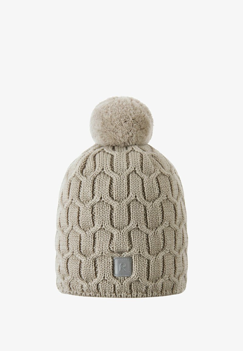 Beige knitted winter hat with honeycomb pattern and large pom-pom on top, featuring a small square logo patch on the front.