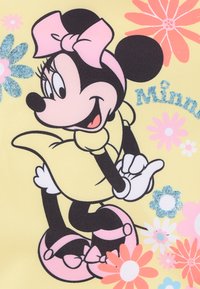 Minnie Maus Illustration auf gelbem Hintergrund, mit pinkem Kleid, pinker Schleife und glitzernden Akzenten, umgeben von bunten Blumen.