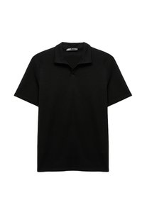 Polo shirt nera in un tessuto testurizzato, con colletto e maniche corte. Il design è uniforme, senza motivi o accenti visibili.