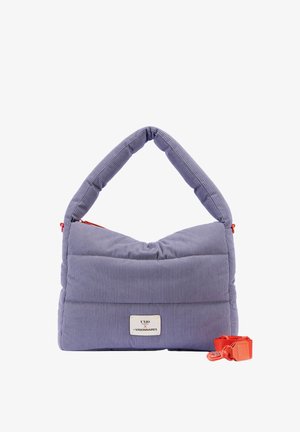 Sac à main en velours côtelé lavande rembourré avec une large poignée, une étiquette rectangulaire et une bandoulière amovible orange vif posée à côté sur un fond blanc.