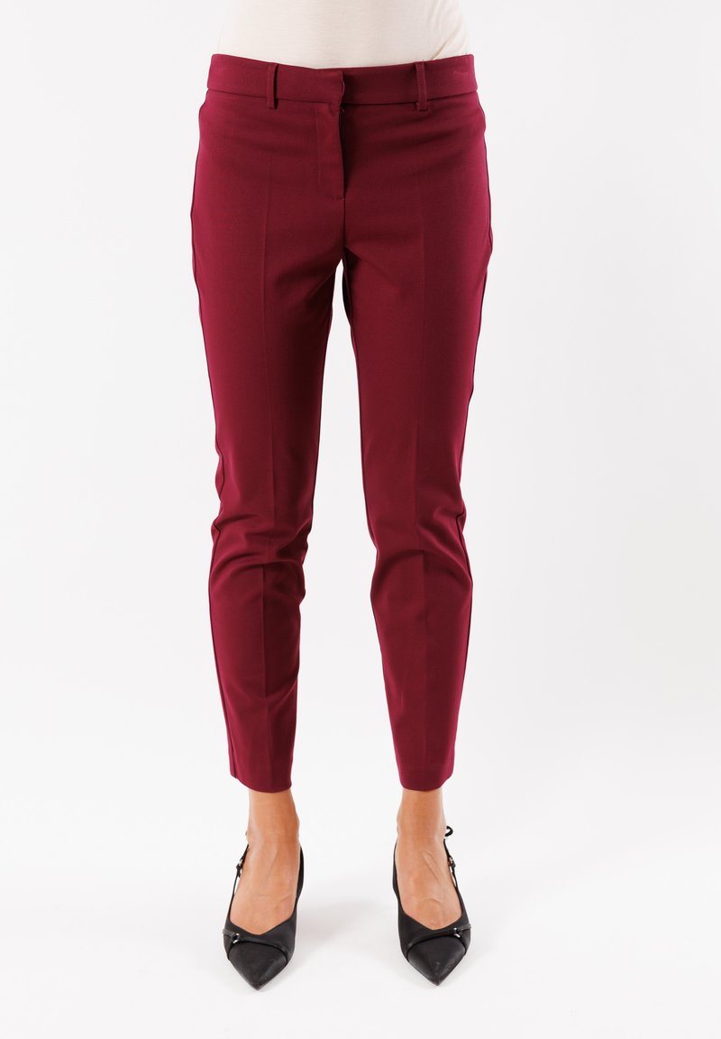 Pantaloni sartoriali borgogna realizzati in materiale liscio, con una vestibilità slim, tasche laterali e una vita di altezza media, abbinati a tacchi neri.