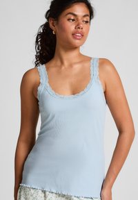 Lichtblauw geribbeld tanktopje met kantafwerking. Heeft brede schouderbanden en een ronde halslijn. Soepele textuur met geschulpte randen.