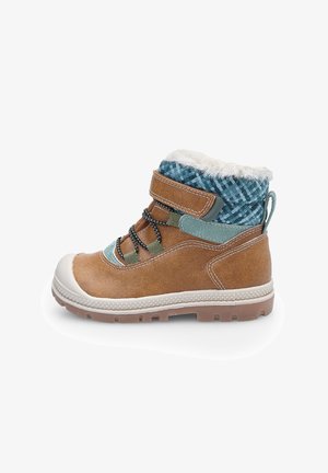 Child’s brown winter boot with fur lining, blue patterned ankle cuff, velcro strap, and rugged sole on a white background.