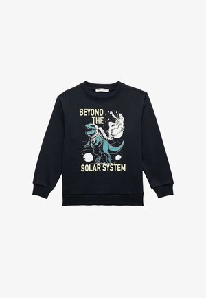 Sudadera negra con un diseño gráfico de un dinosaurio y un astronauta, acompañado del texto "BEYOND THE SOLAR SYSTEM" en acentos de amarillo claro y verde azulado.
