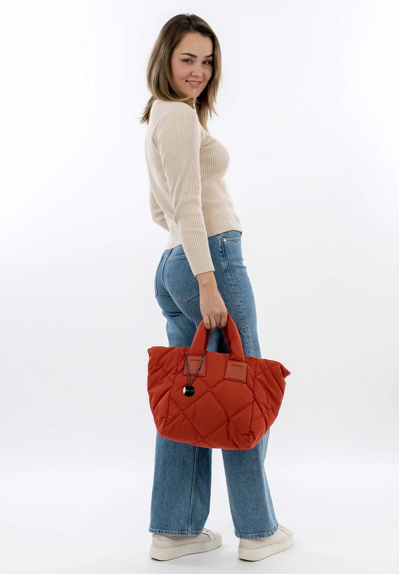 Borsa a tracolla rosso trapuntata con due manici e un charm decorativo. La borsa ha una consistenza morbida e una forma quadrata, adatta per un uso casual.