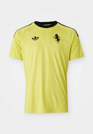 Gul sportsmærke skjorte med sorte accenter, korte ærmer, rund hals, har Adidas-logo og et tekstureret sort hestegrafik på forsiden.