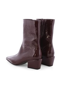 Bordeaux-lackleder Stiefeletten mit quadratischer Zehenform und Blockabsatz. Texturierte Oberfläche mit glattem Finish, ausgestattet mit einem seitlichen Reißverschluss.