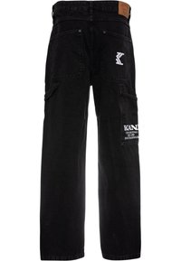 Pantaloni cargo in denim nero con vestibilità ampia, caratterizzati da molteplici tasche e branding ricamato bianco sul lato. Superficie testurizzata.