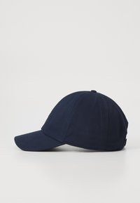 Navy blue cotton baseball cap with curved brim, top button, and adjustable back strap placed on a white surface.