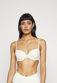Reggiseno beige con ferretto, coppe morbide e modellate, design minimalista, spalline sottili regolabili e una comoda texture simile alla satin.