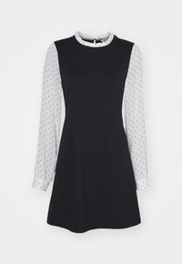 Musta mekko, jossa on pitkät valkoiset pallokuosiset hihat ja pyöreä kaula-aukko. Siinä on muotoiltu bodice ja laajahelma, valmistettu sileästä kankaasta.